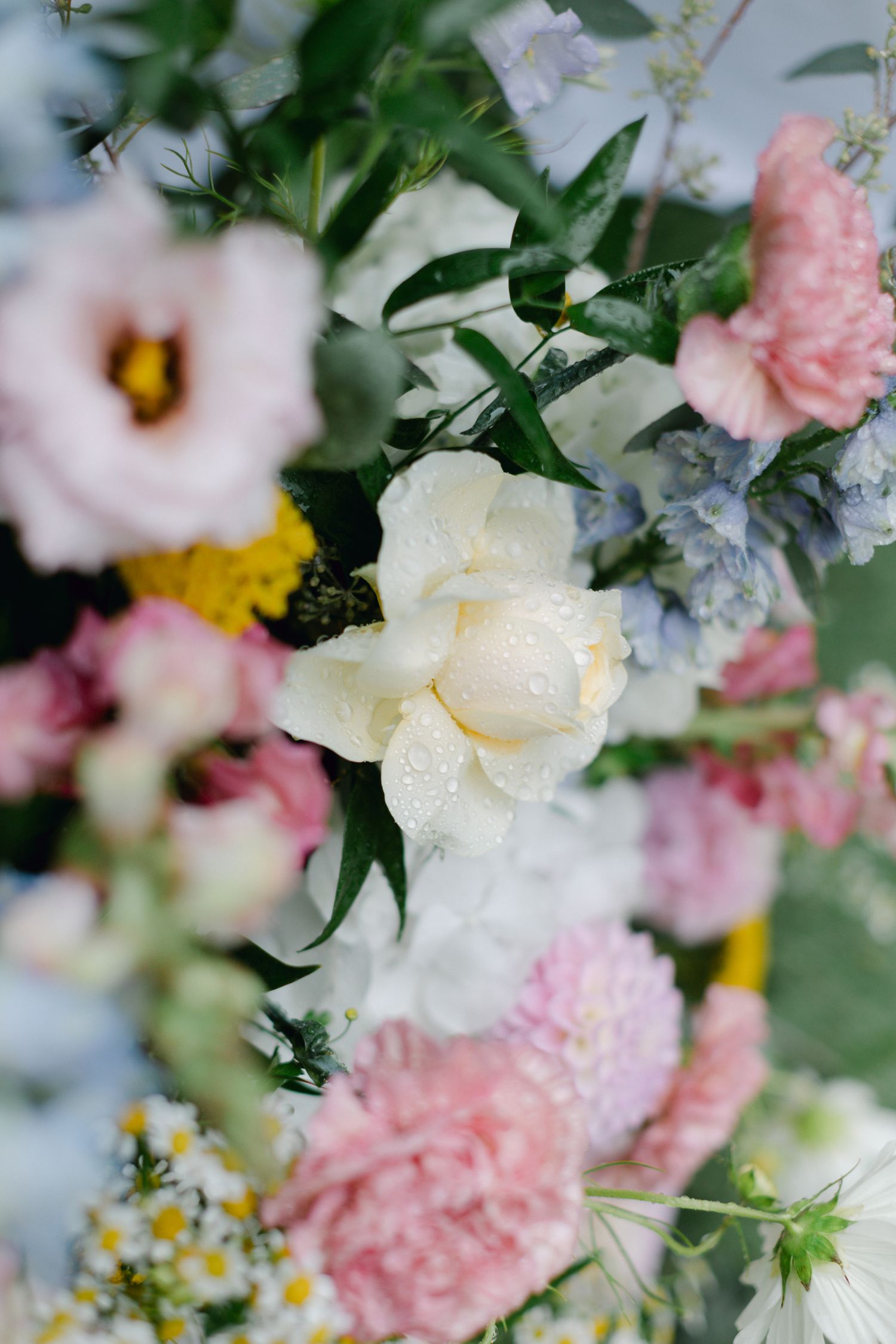 Gros plan d'un bel arrangement floral de mariage avec des fleurs blanches, roses, bleues et jaunes.