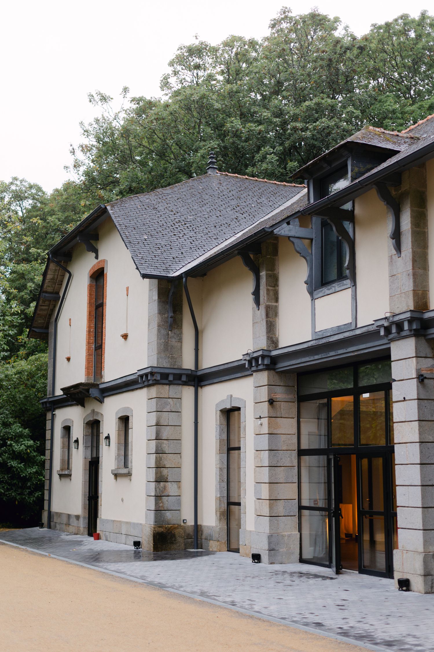 Élégant lieu de mariage à la campagne française extérieur avec une architecture en pierre et des arbres verts luxuriants.