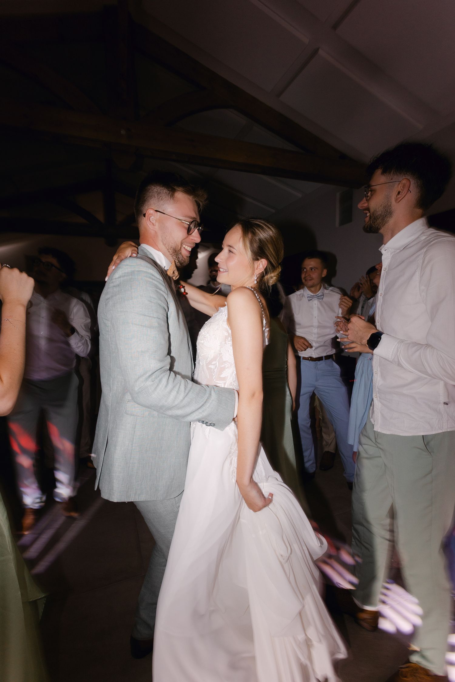 La mariée et le marié partagent une danse joyeuse ensemble lors de leur réception de mariage entourés d'invités.