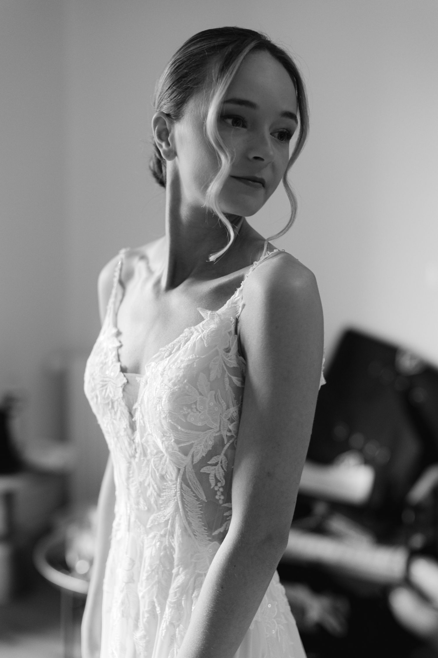 Portrait en noir et blanc d'une mariée en robe de mariée en dentelle pendant les préparatifs nuptiaux.