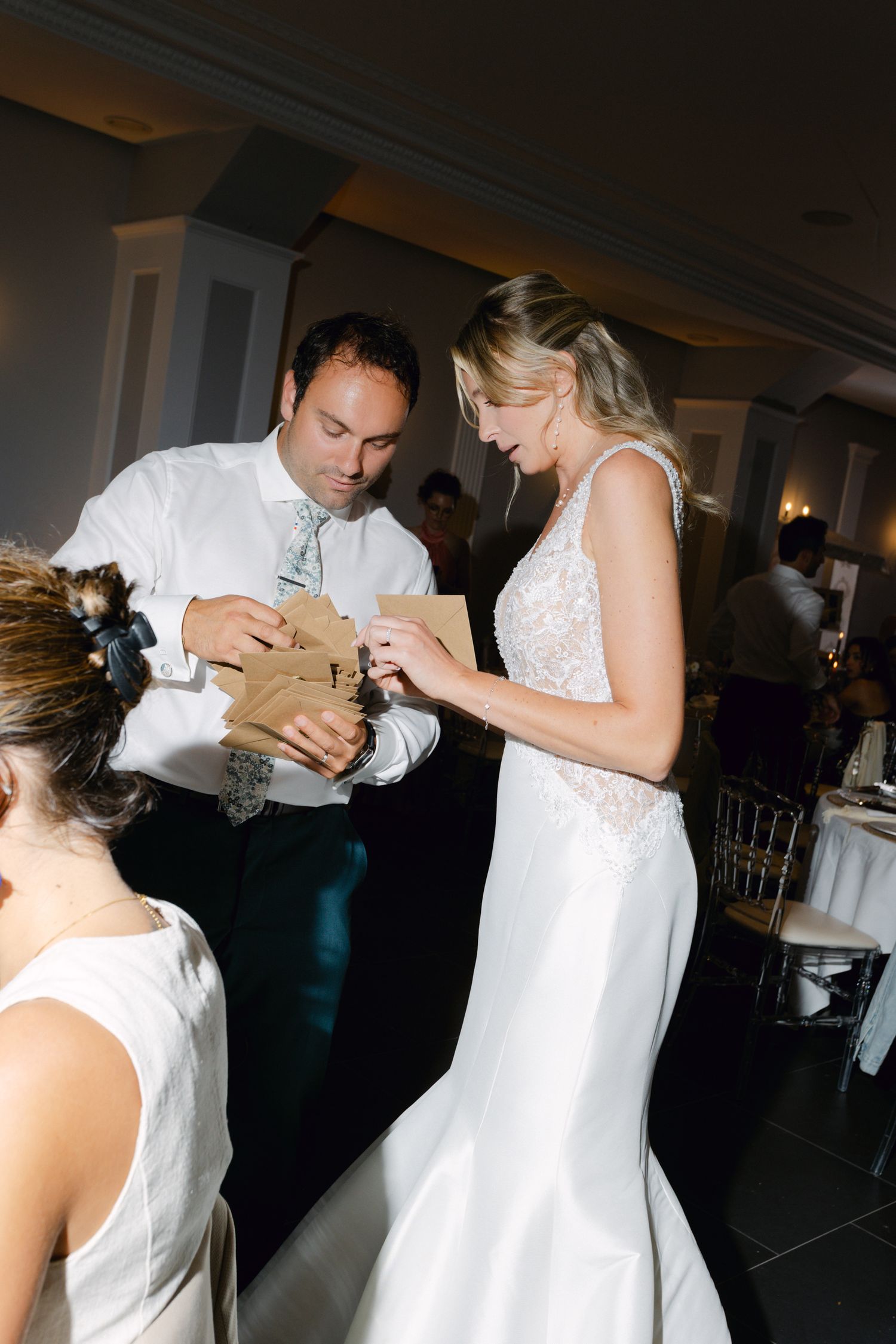 La mariée et le marié ouvrent ensemble des sacs cadeaux en papier brun lors de la célébration de la réception de mariage.