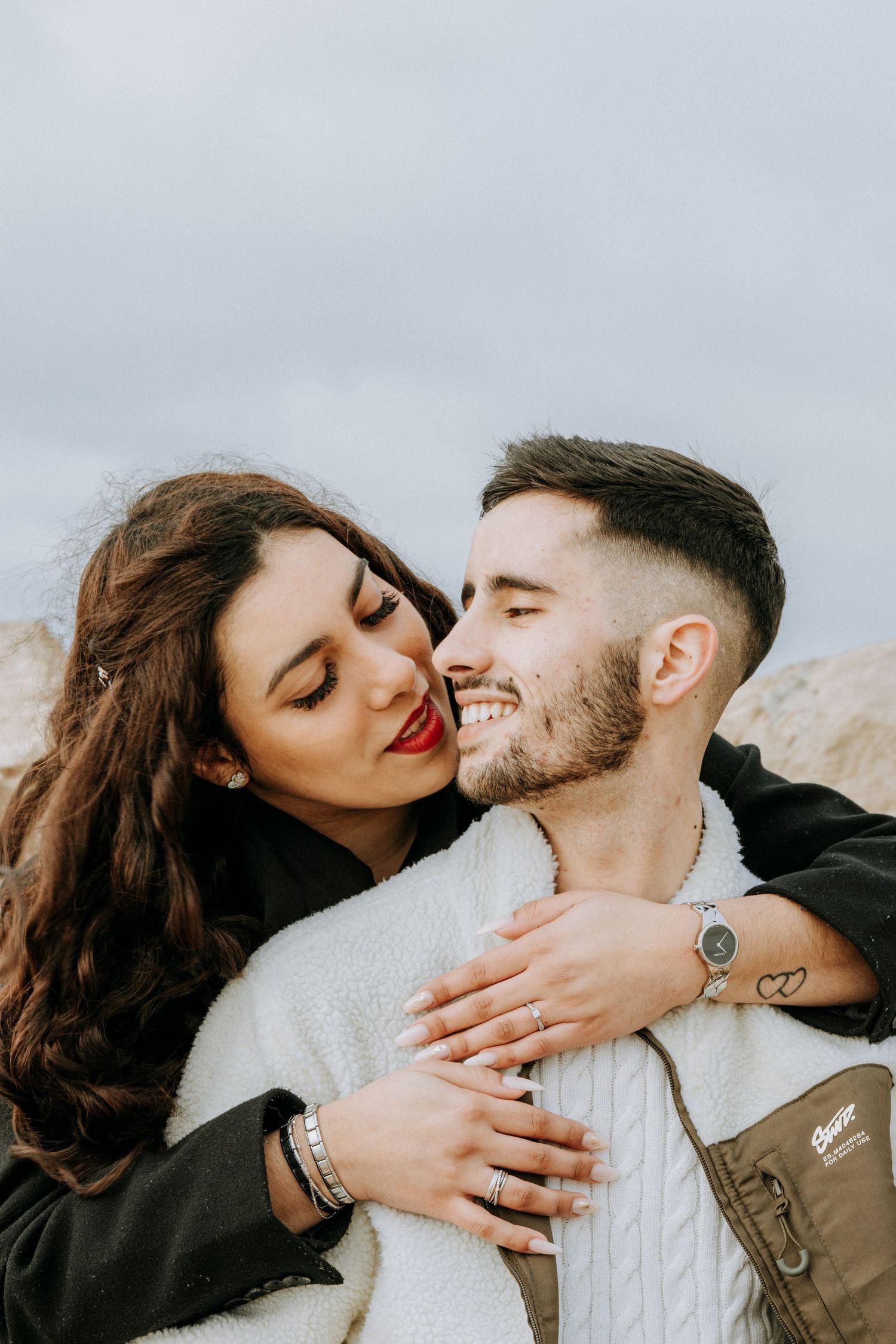 An intimate moment between a couple sharing laughs and embraces outdoors.