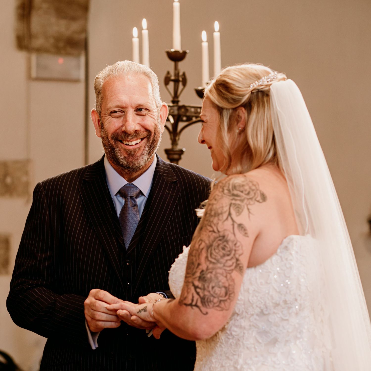 Wedding ceremony moment with candlelit altar backdrop.