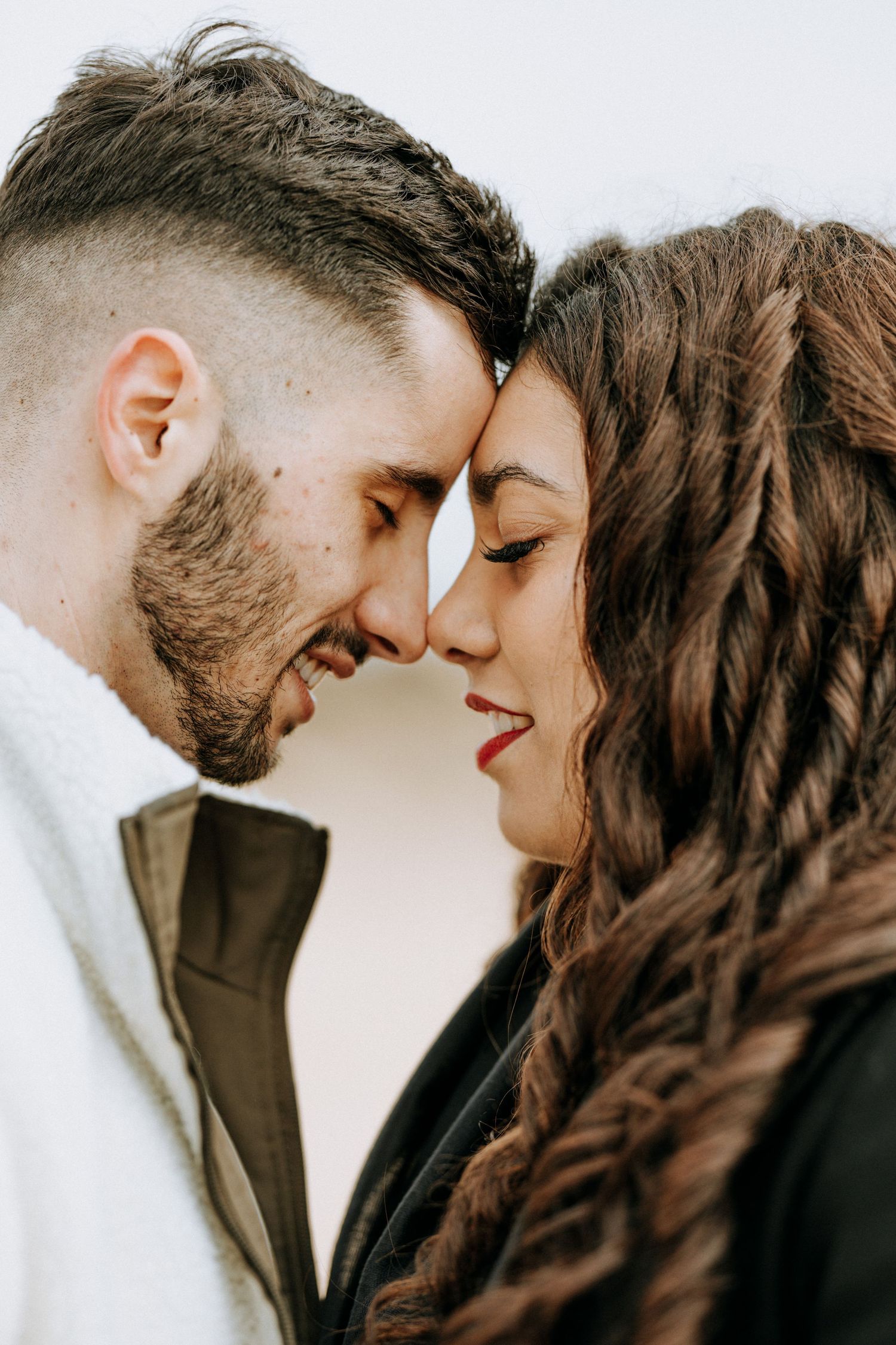 A tender close-up moment between a couple with their foreheads touching.