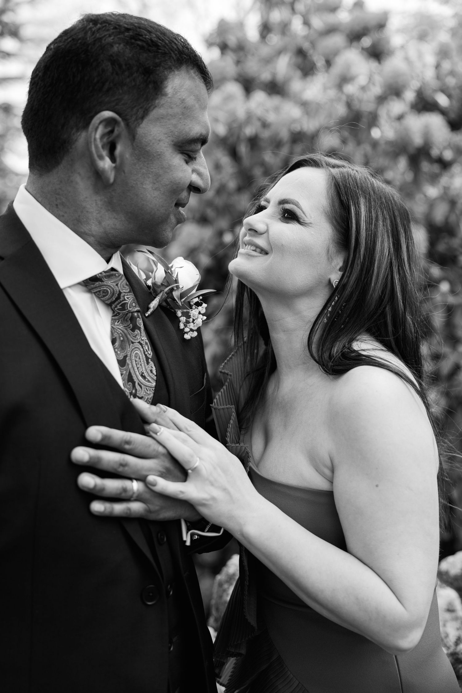 A romantic black and white portrait of a couple sharing an intimate moment during their wedding ceremony.