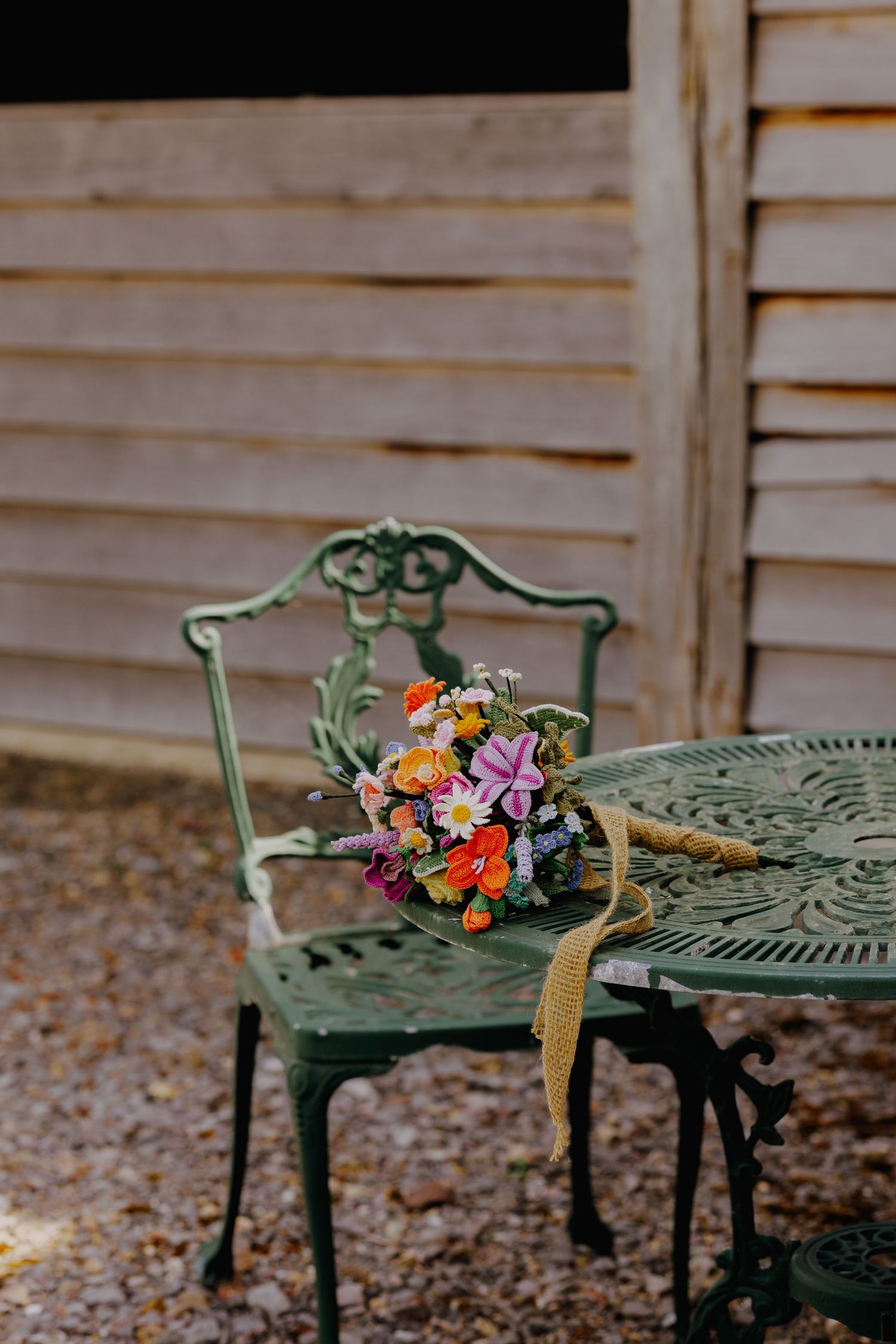 Colorful wildflower bouquet rests on vintage green metal patio furniture outdoors.