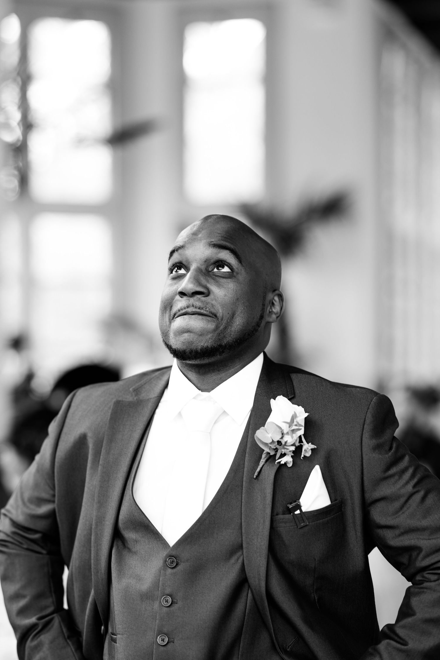 Black and white portrait of a groom in a three-piece suit with boutonniere.