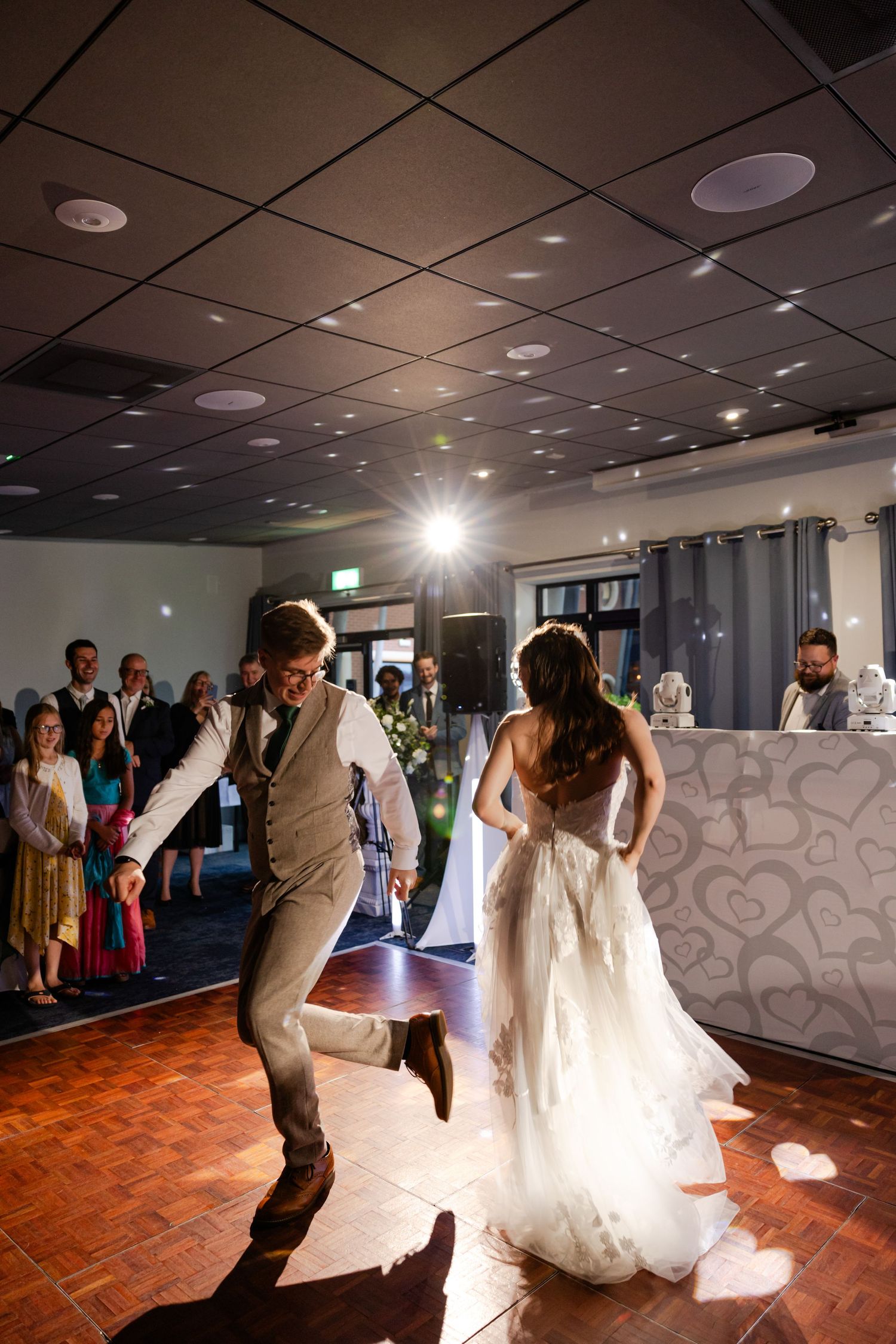 Wedding couple dancing on illuminated dance floor during reception.