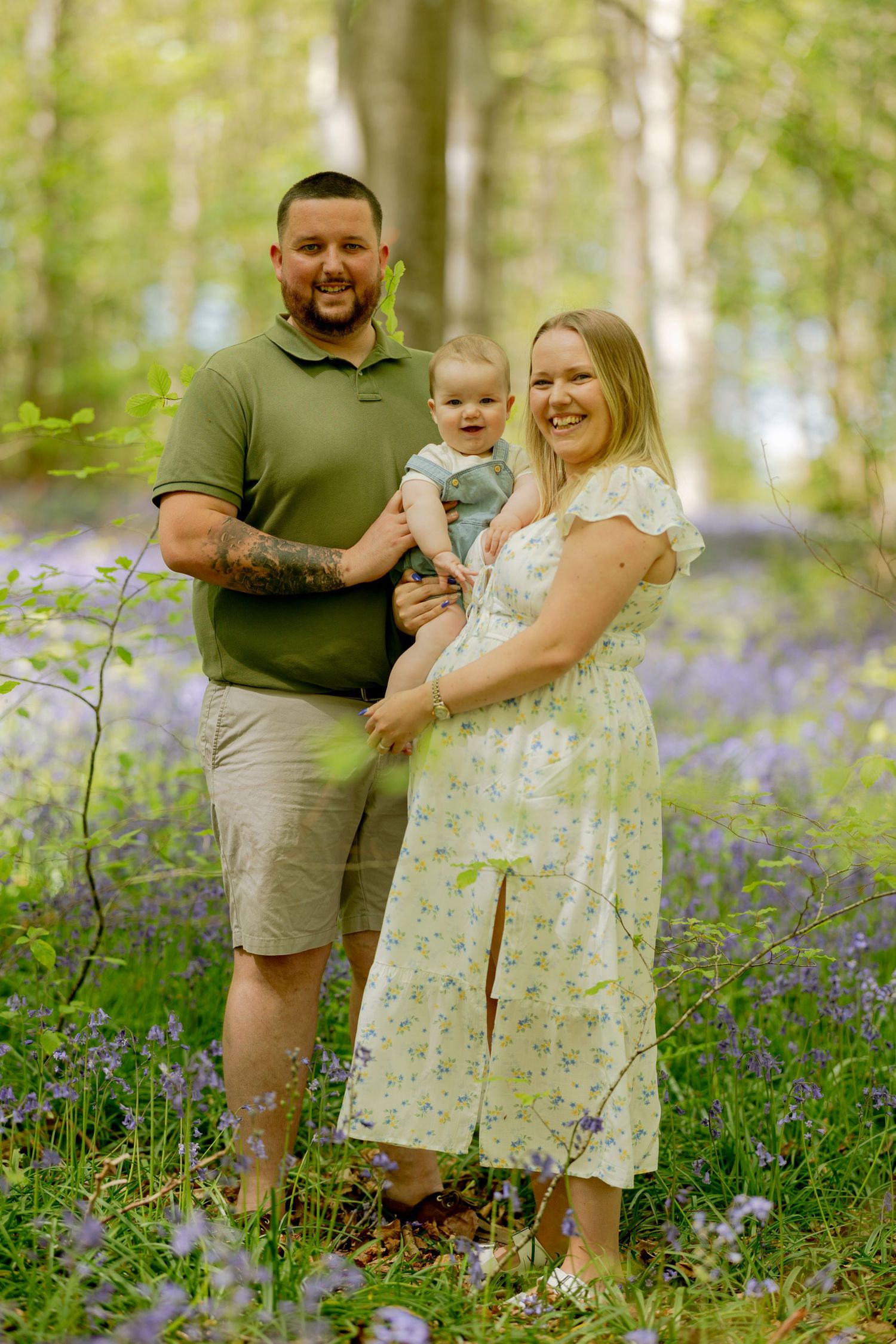 Family portrait taken in spring woodland surrounded by blooming bluebells.