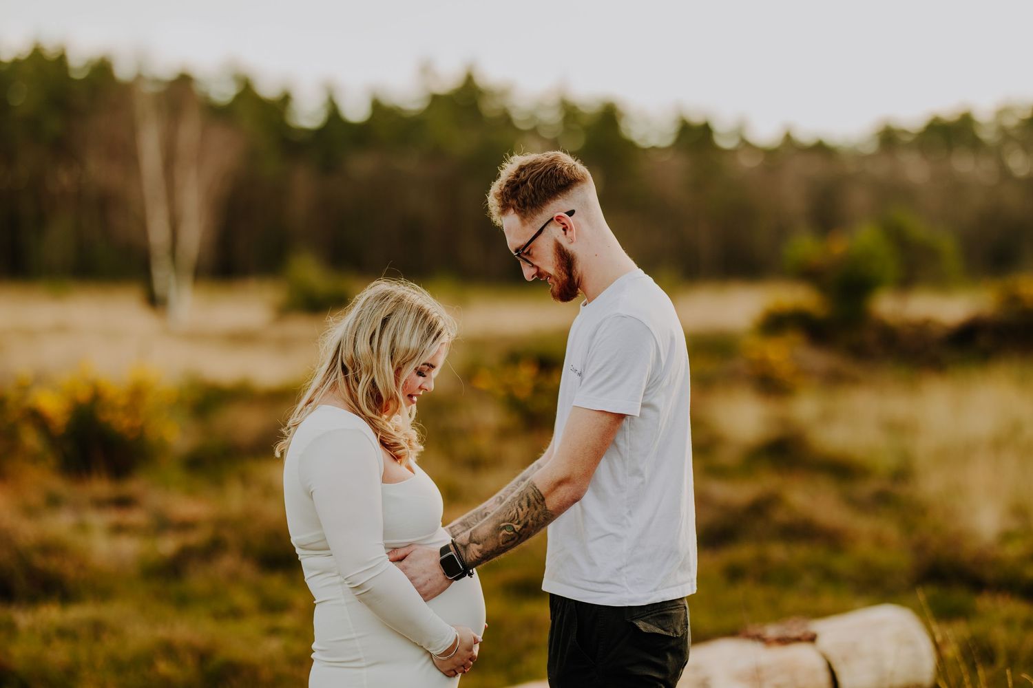 Couple sharing a tender moment together in a sunlit outdoor setting during a photo session.