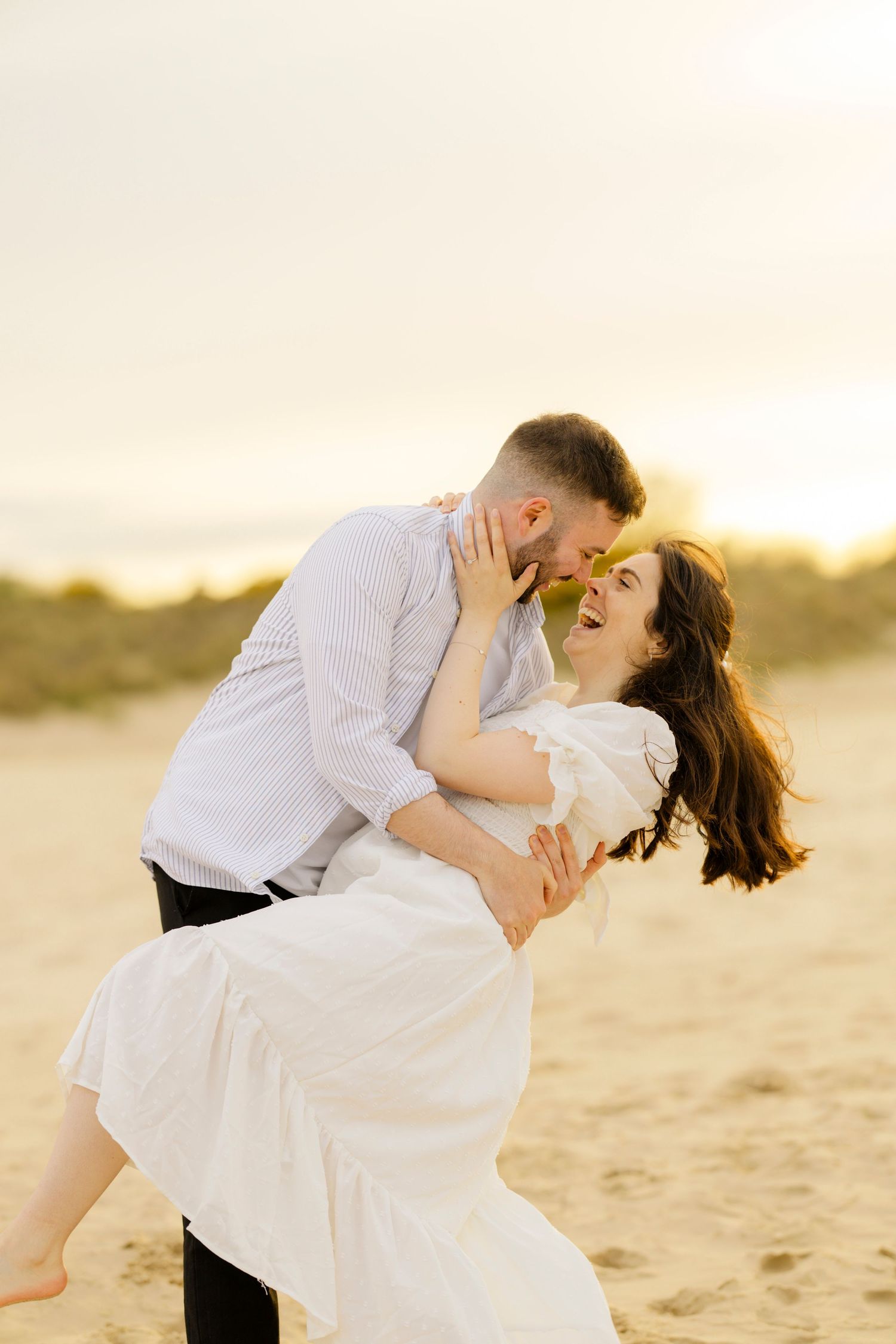 Romantic dip pose on beach during golden hour sunset.