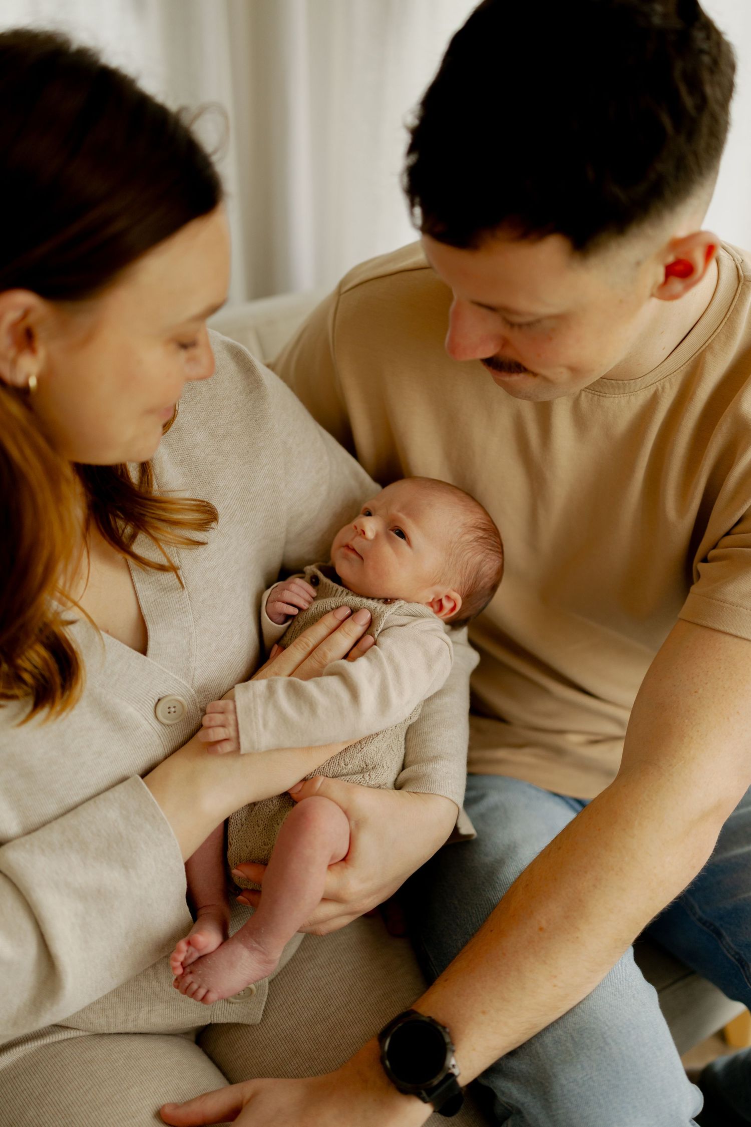A family shares tender moments with their newborn baby in a series of intimate lifestyle photos at home.