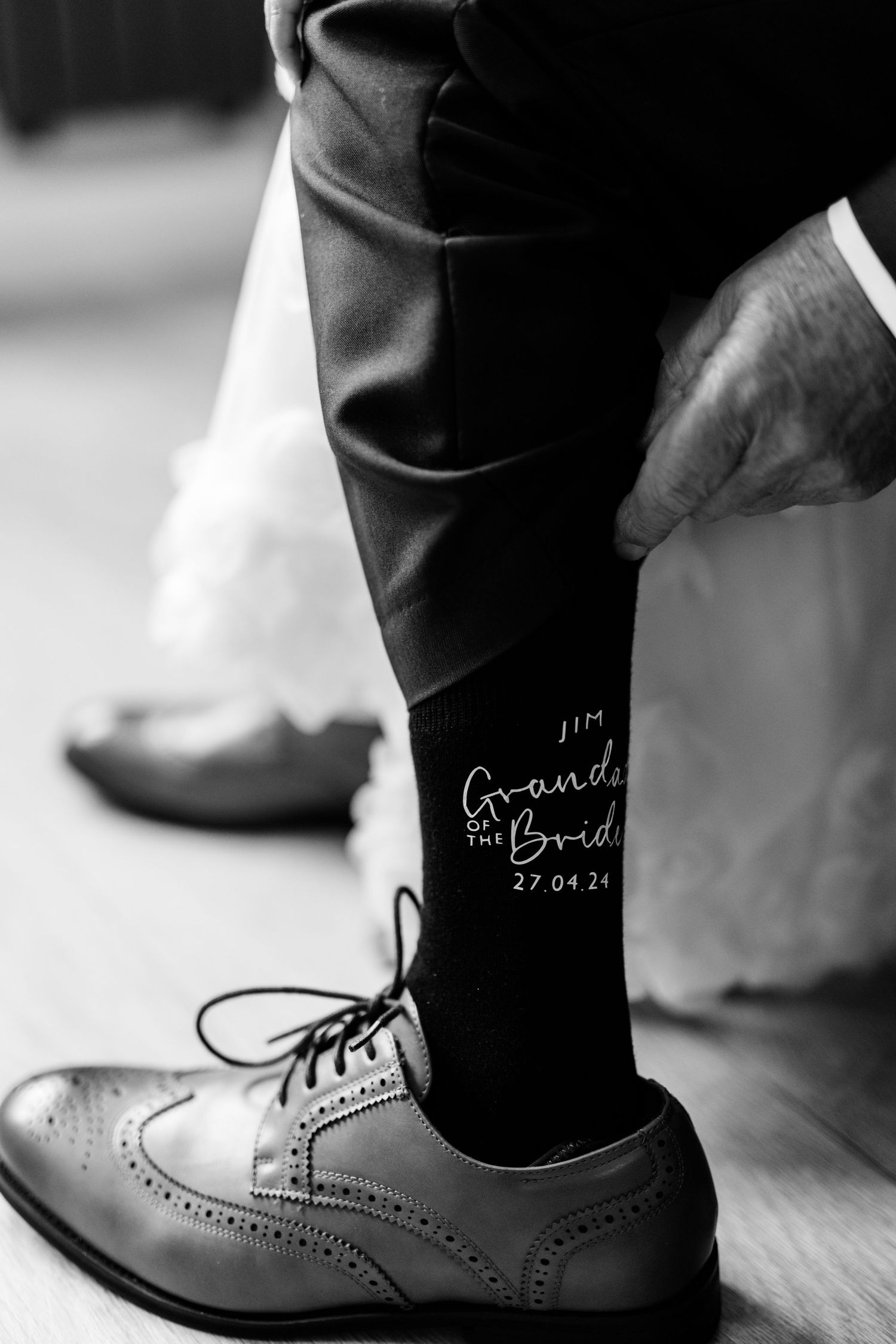 Black and white detail shot of custom wedding socks and dress shoes.