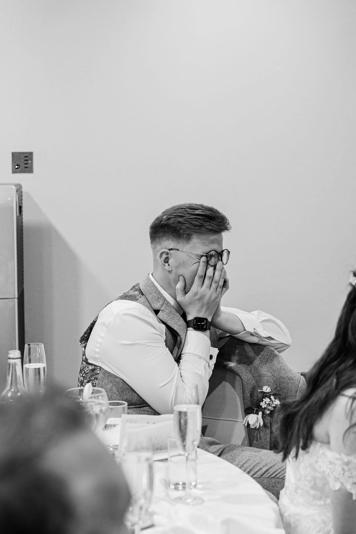 Black and white photo of an emotional moment during a wedding reception.