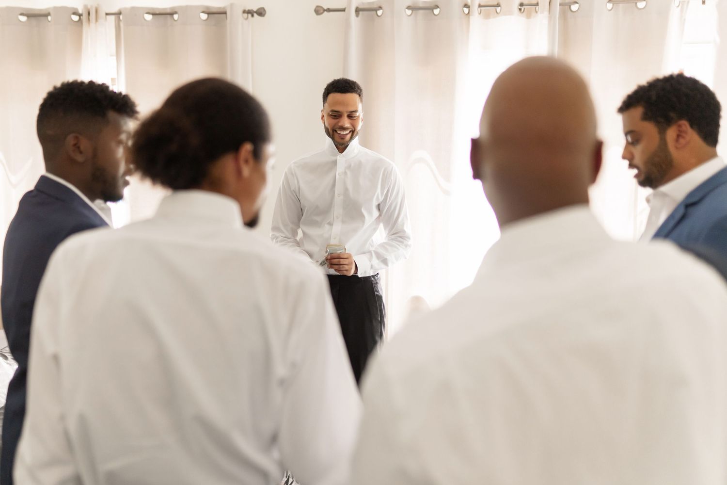 Healthcare professionals wearing white lab coats gather in a bright room for a medical conference or meeting.
