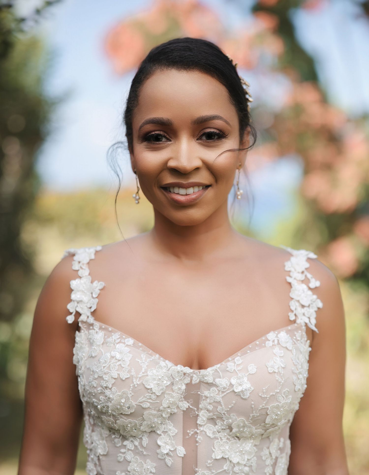 A close-up portrait series of someone wearing a white lace wedding dress with floral appliques in an outdoor setting.