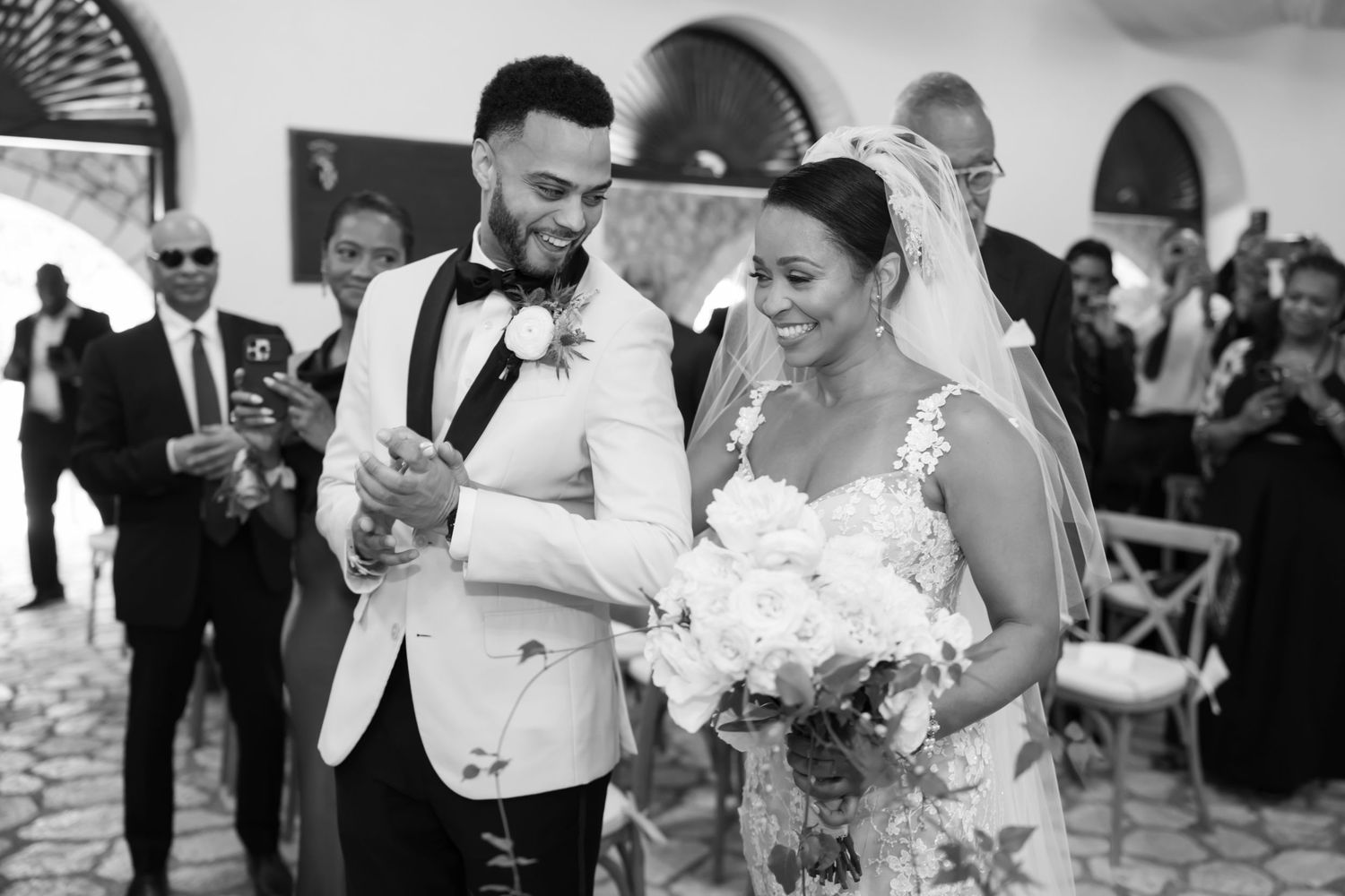 A joyful couple dances together during their black and white wedding reception celebration.
