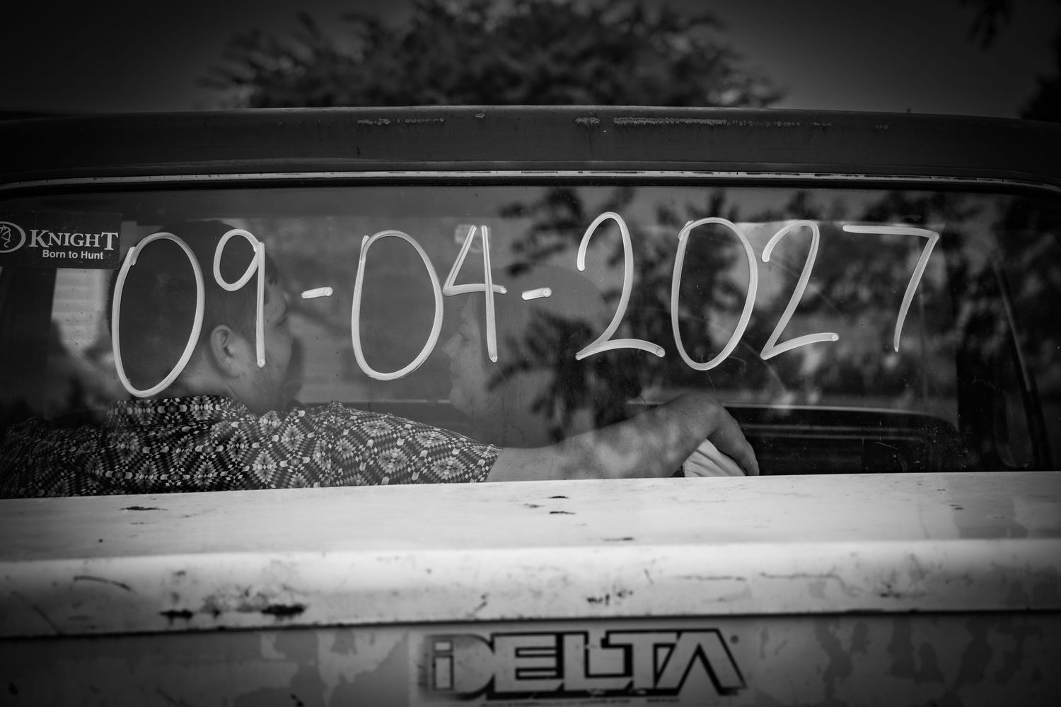 Black and white photo of wedding date 09-04-2027 written on truck window.