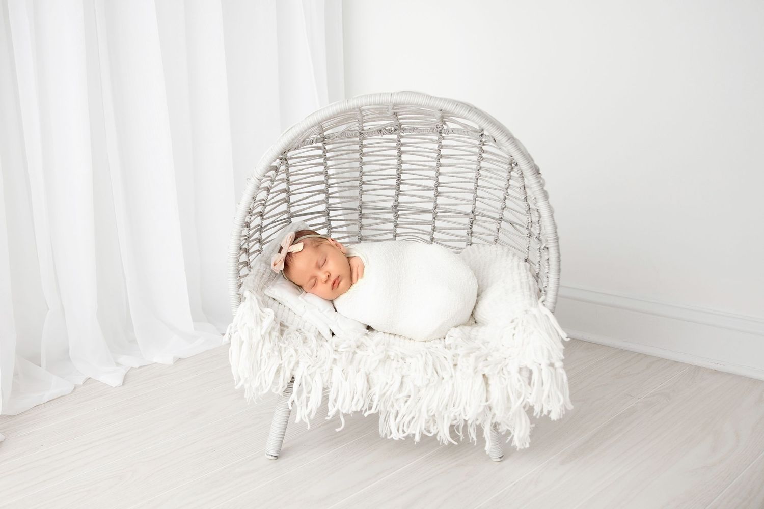 Sleeping newborn baby on soft basket setup during infant photography session