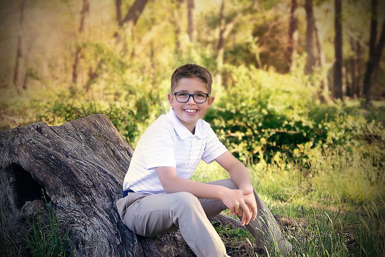 Young boy sitting on rocks during casual family and child photography session in NJ