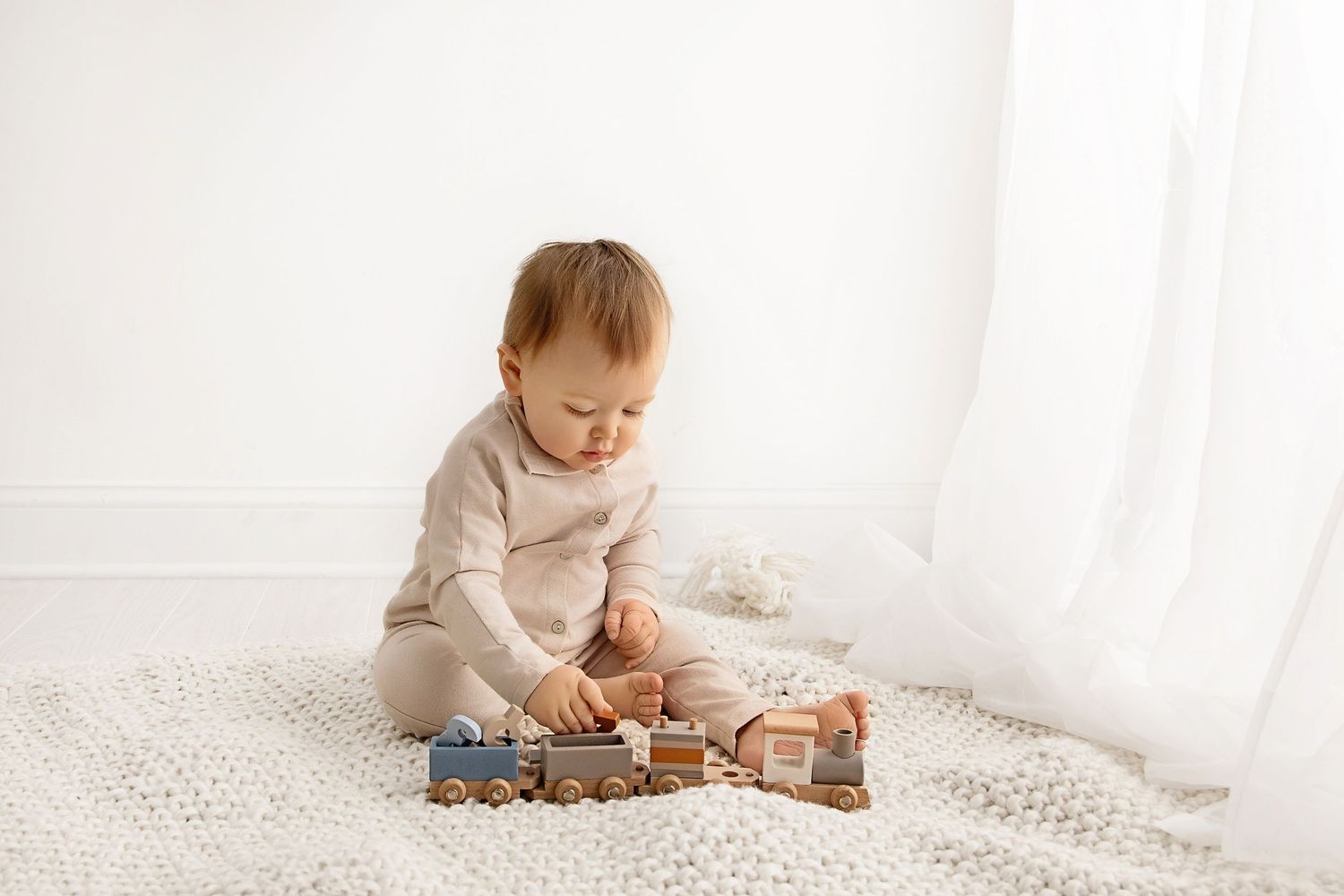 Baby sitting and playing with wooden toys in Toms River NJ milestone photography session