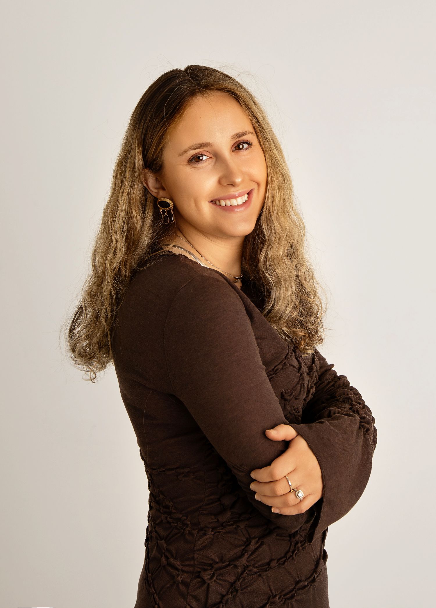 Professional studio portrait series showing poses in a brown sweater against light background.