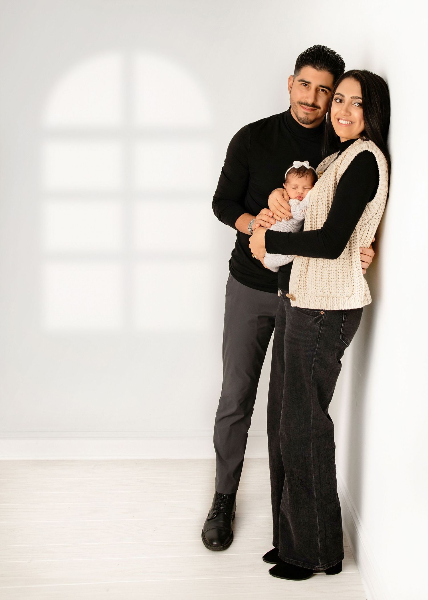 Newborn and family photoshoot, parents holding baby in studio family photography