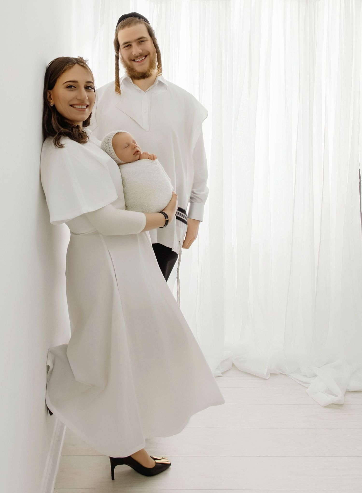 Parents holding newborn baby during family portrait session in Jackson NJ studio