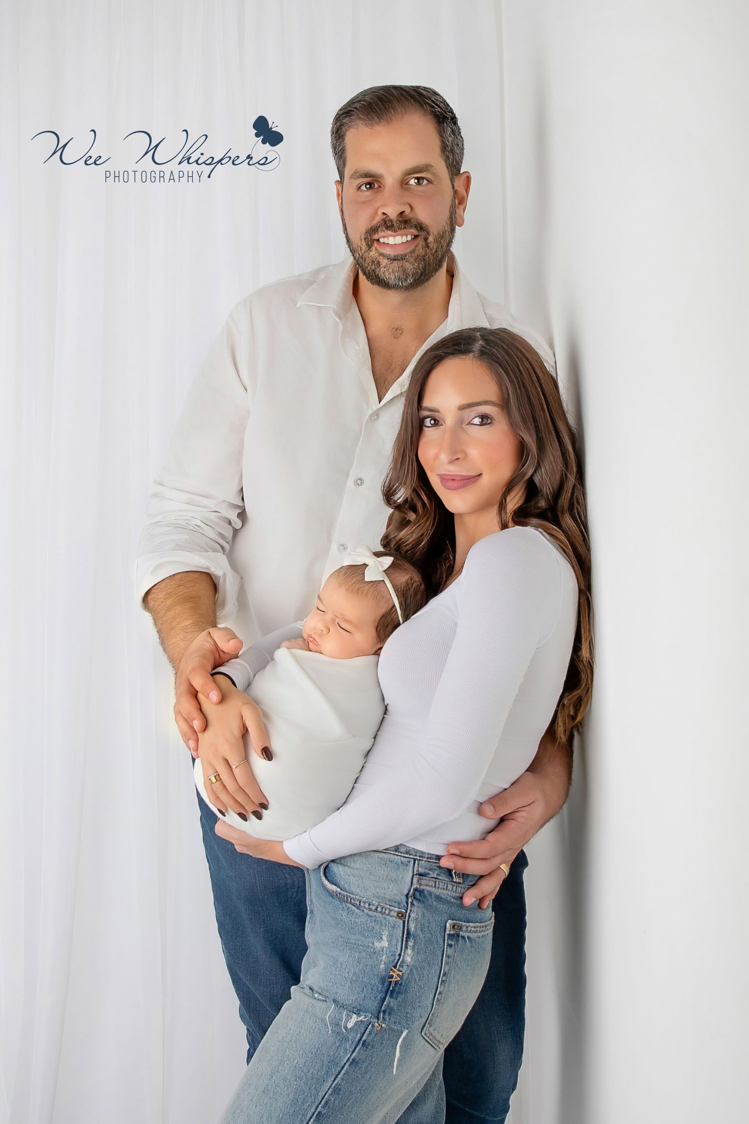 Parents holding newborn baby together during natural family photography session