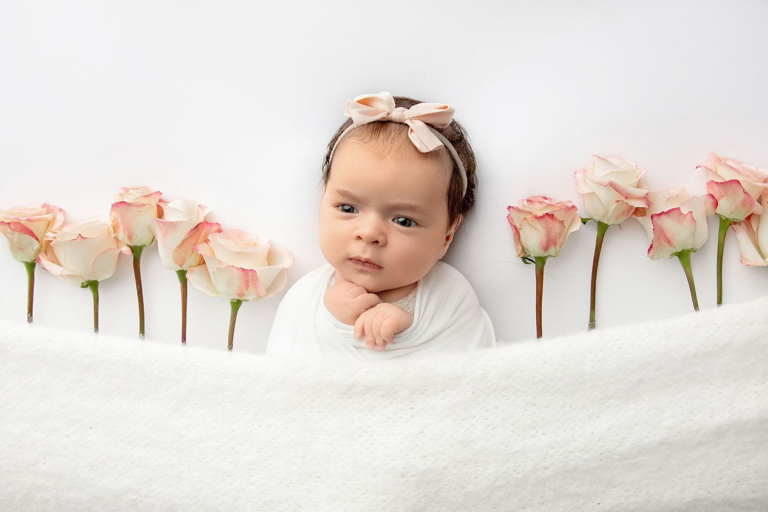 Close up of baby girl with bow headband during newborn pictures session