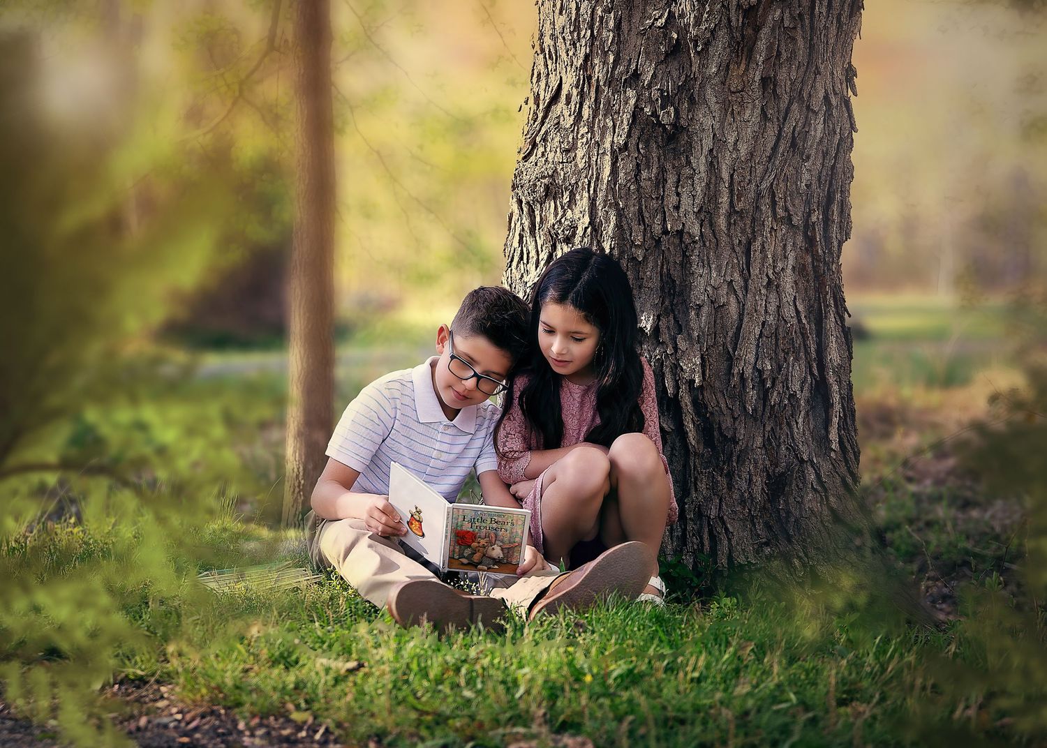 Family sitting under a large tree during outdoor family photoshoot in Central New Jersey