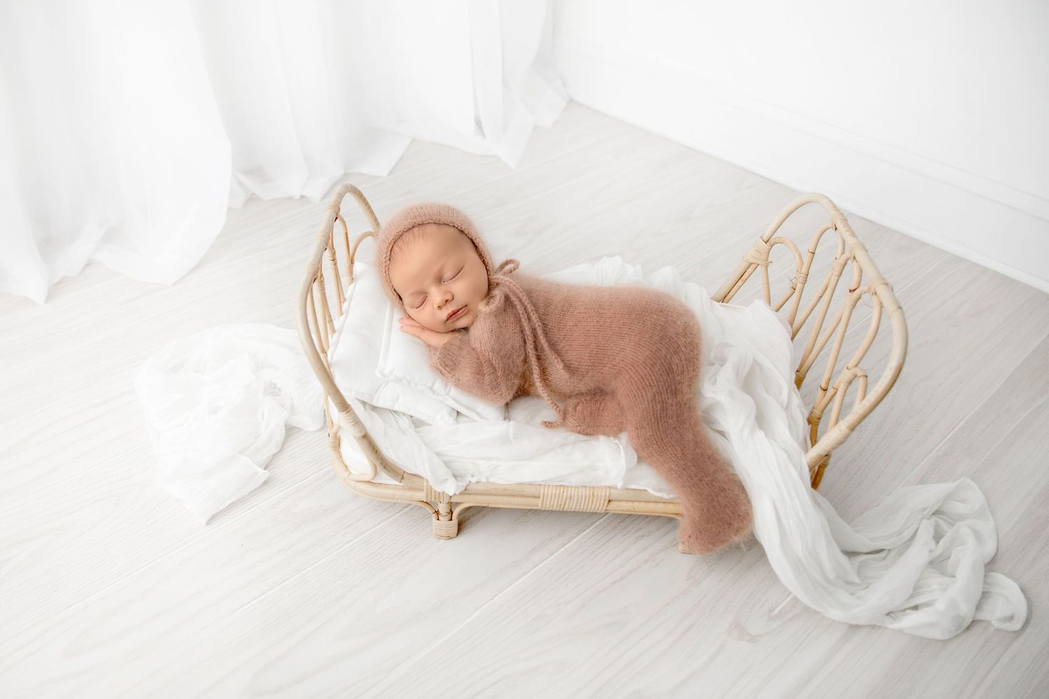 Sleeping baby in soft knit outfit styled for new born photography session