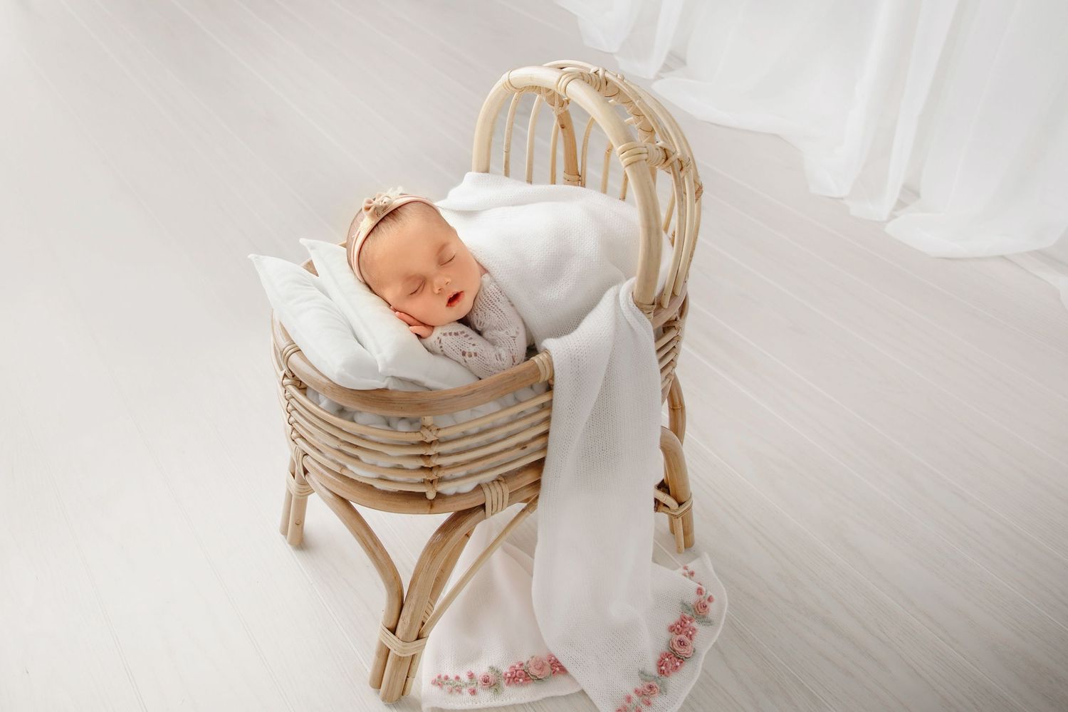Newborn baby sleeping in basket setup for newborn photography session with soft neutral styling