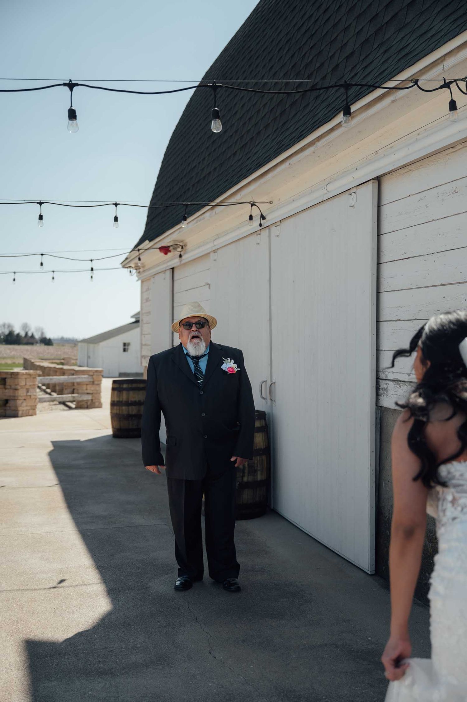 Father seeing bride for the first time during an outdoor first look at a rustic barn wedding venue.