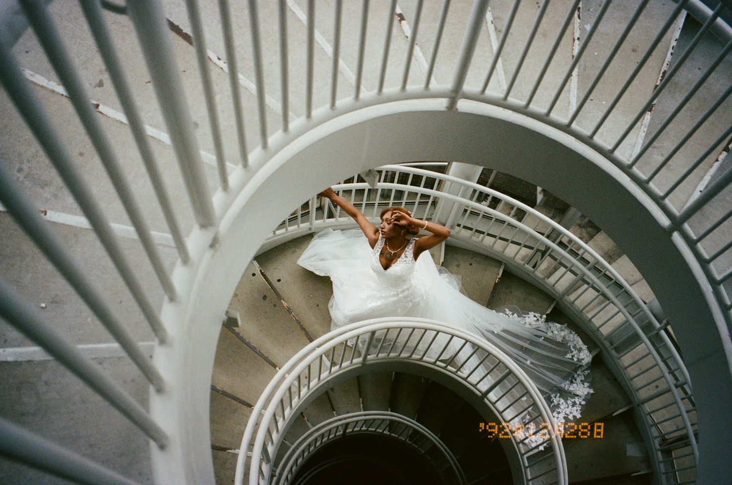 Looking up at a white spiral staircase with modern architectural design and natural lighting from above.