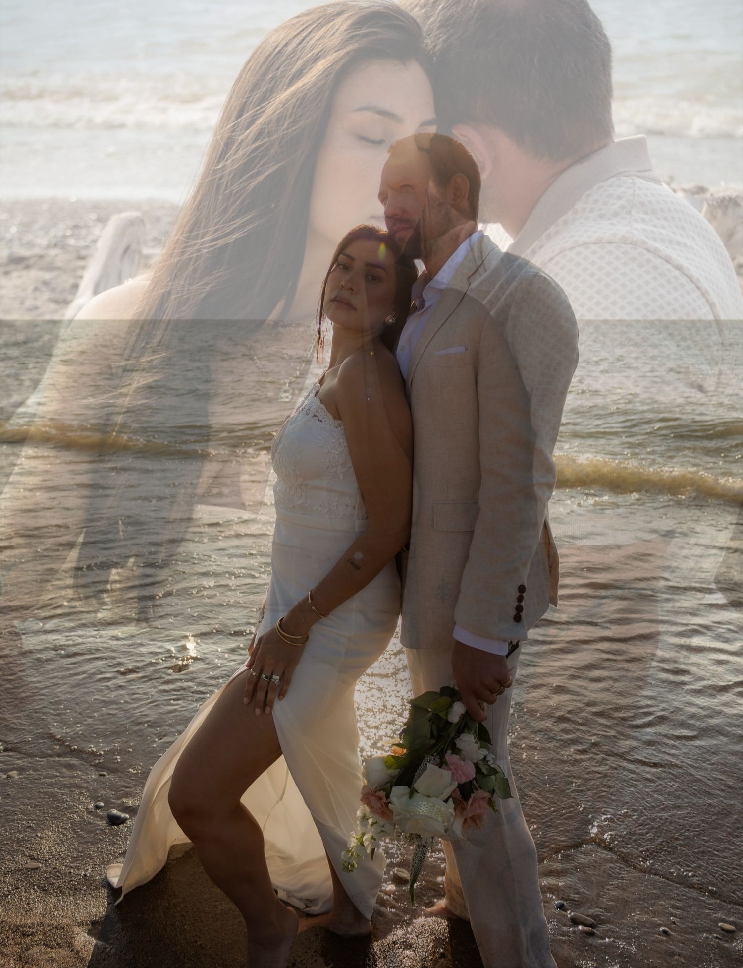 A romantic couple embraces on a misty beach at sunset creating a dreamy silhouette against the water.