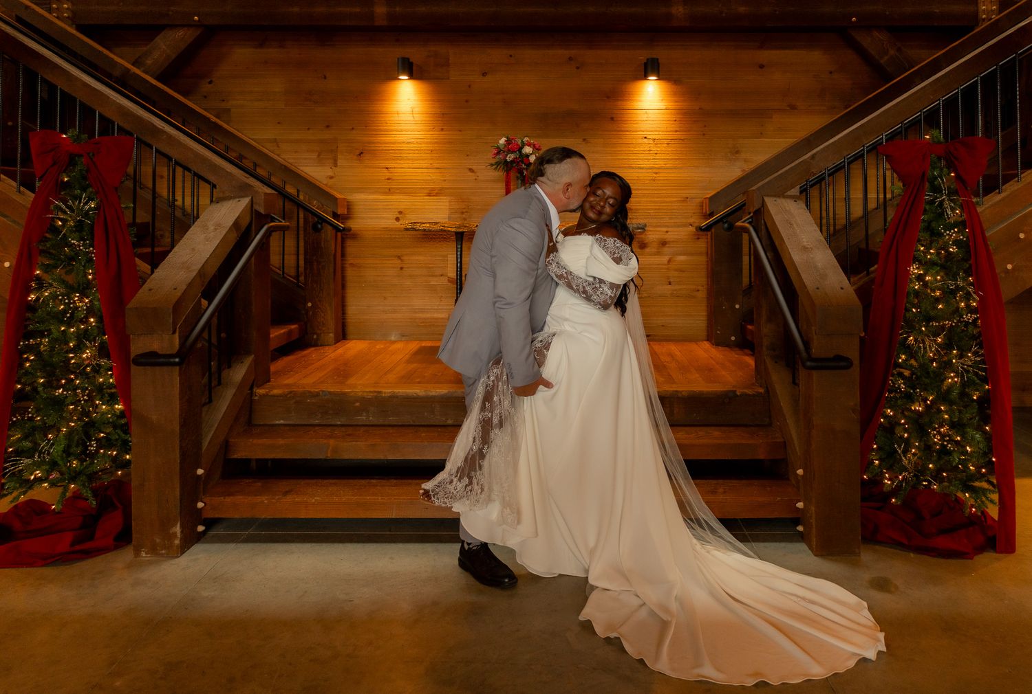 Wedding photos in rustic wooden venue decorated with Christmas trees and warm lighting.