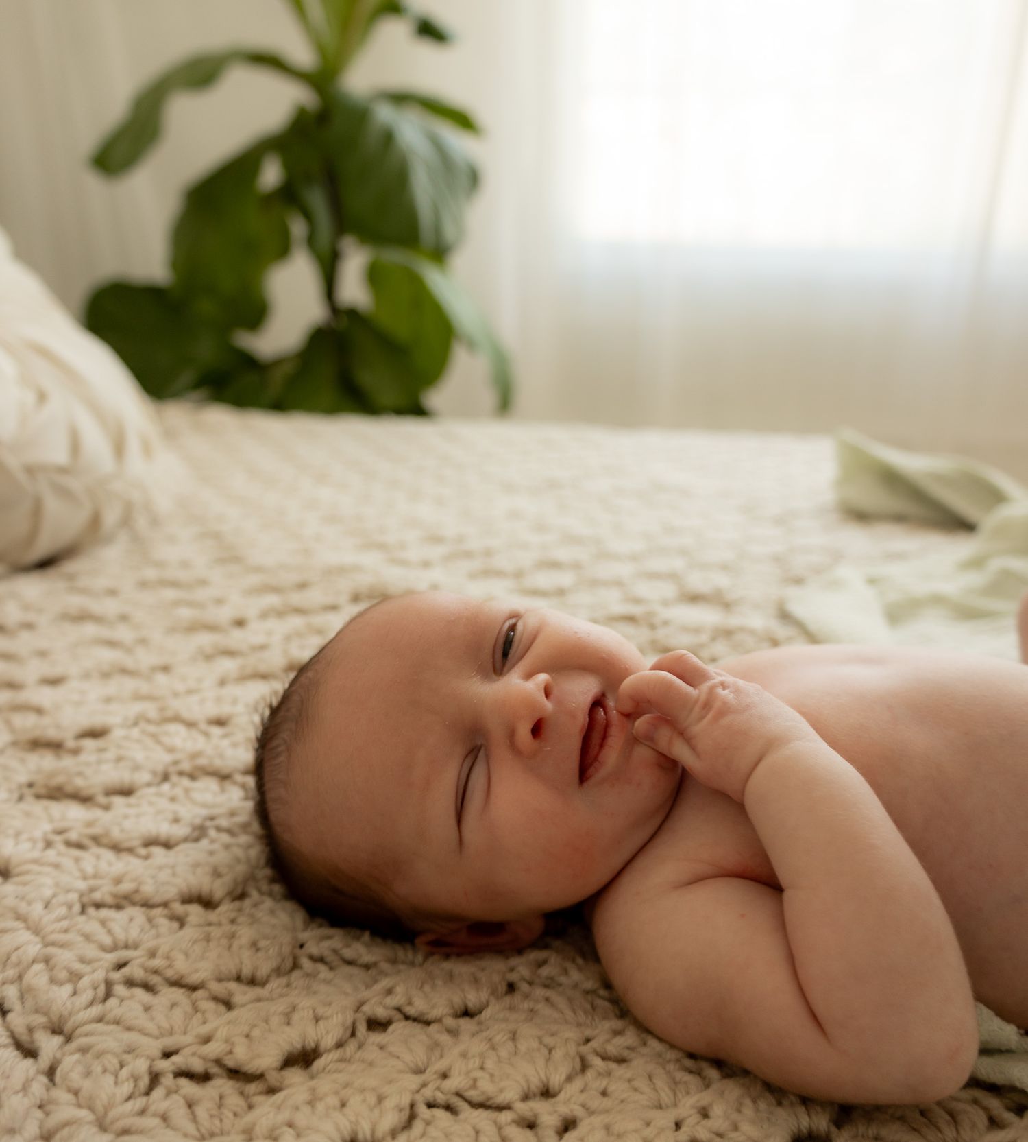 Baby lying on textured cream bedding in various peaceful sleeping poses.