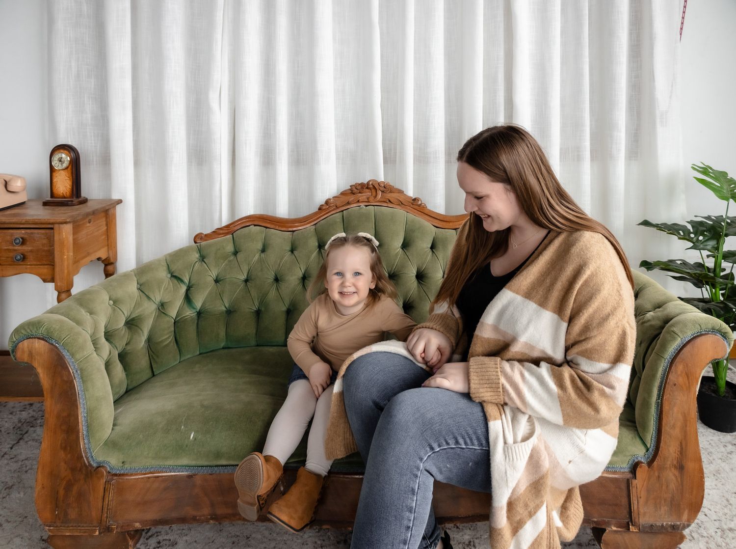 A series of cozy photos showing people relaxing on a vintage green tufted couch indoors.