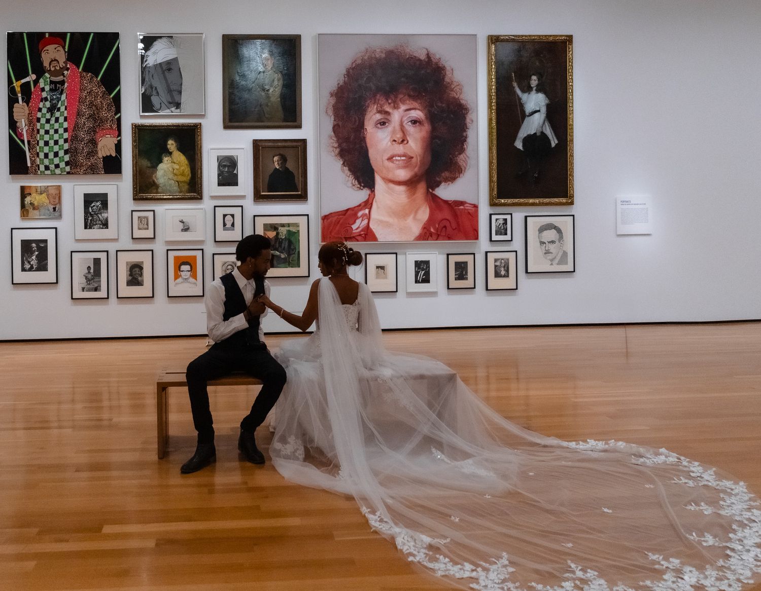 Art gallery interior with long flowing white fabric creating dramatic lines across wooden floor.