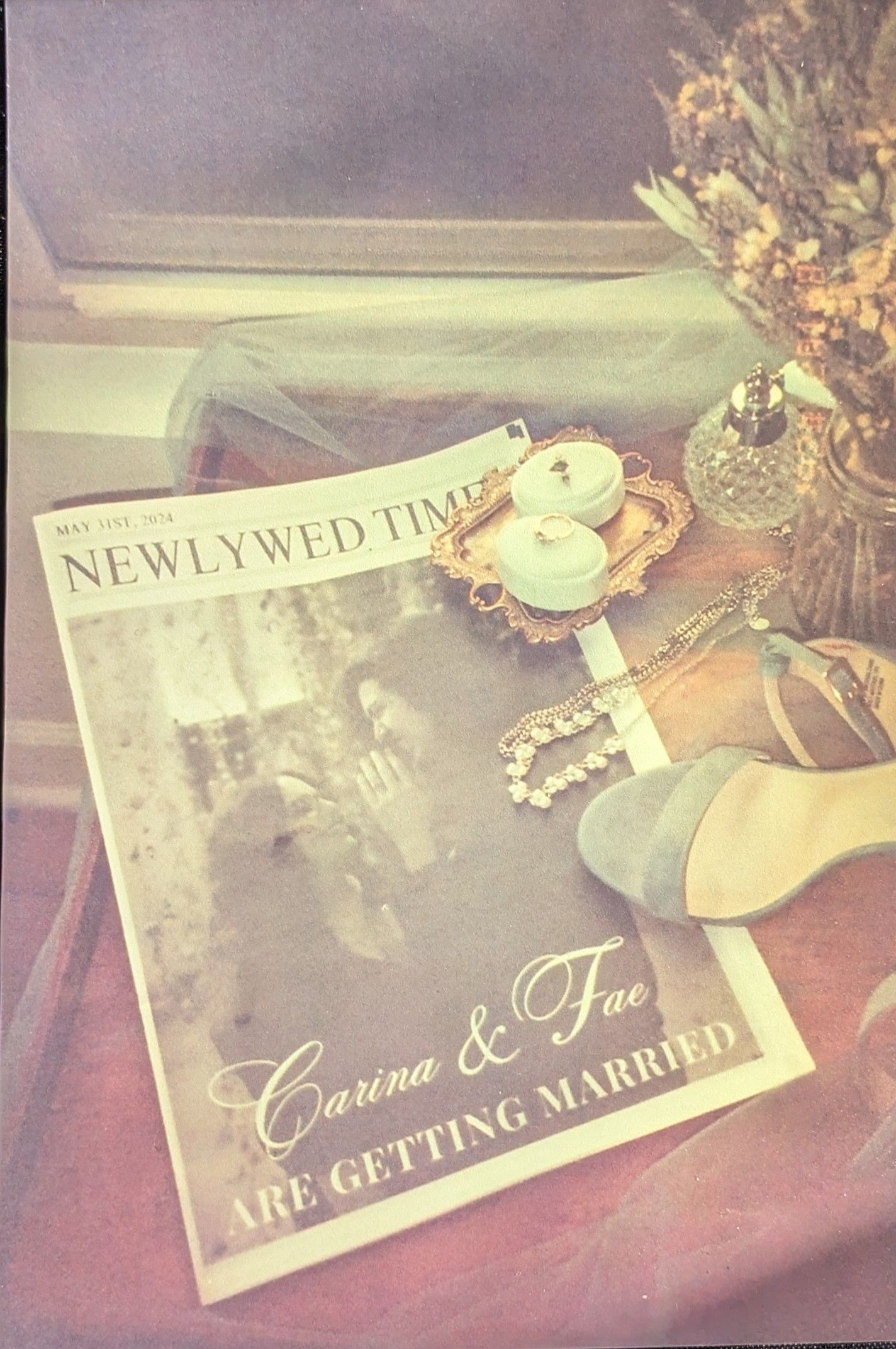 A vintage-style wedding announcement newspaper with pearls, shoes and floral decorations in a romantic sepia tone.