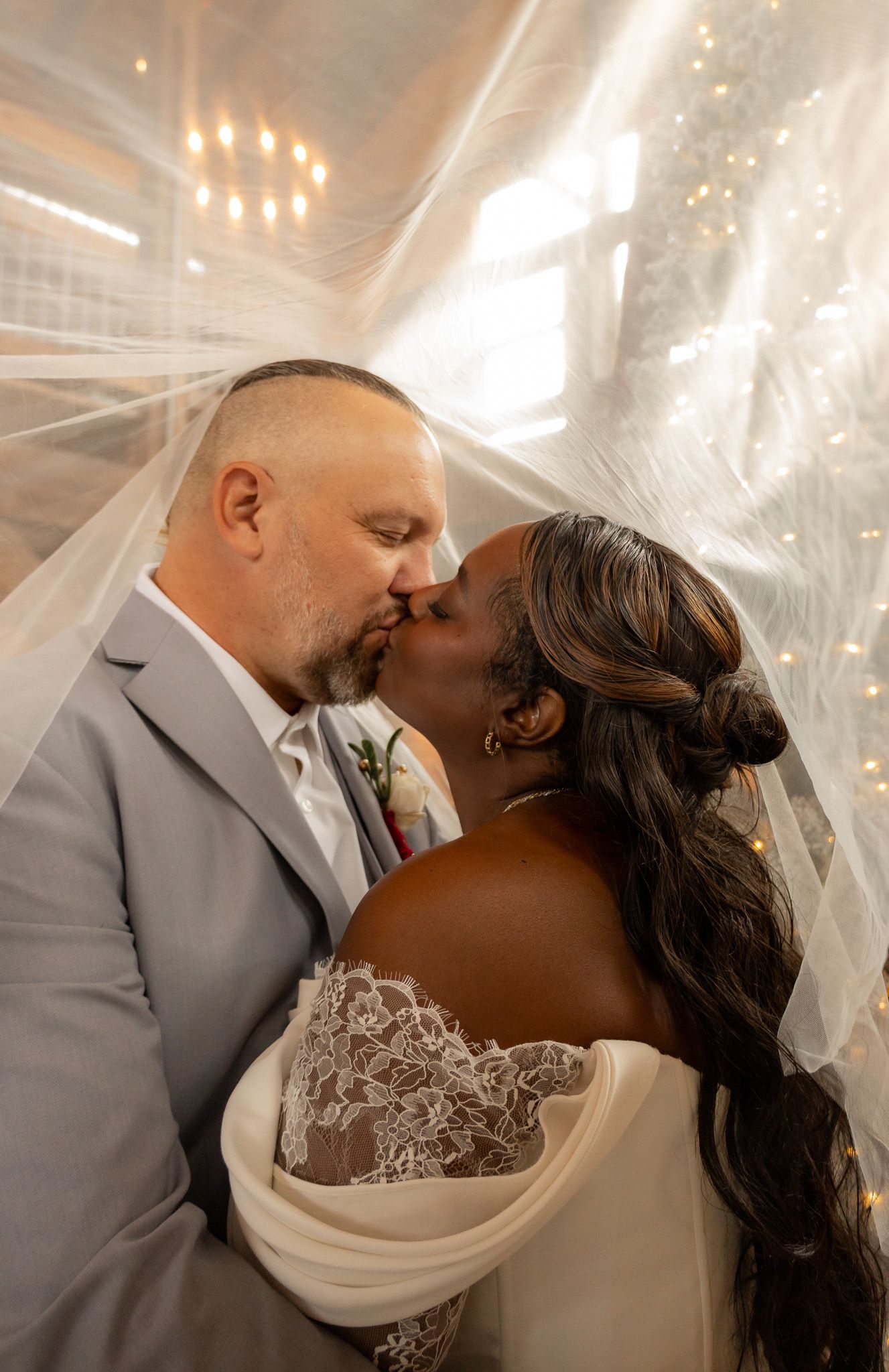 Romantic wedding moment captured under twinkling lights with soft, warm lighting.