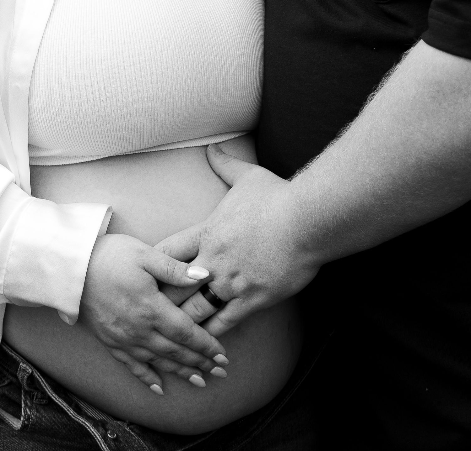 A series of black and white close-up shots showing intertwined hands and tender moments.