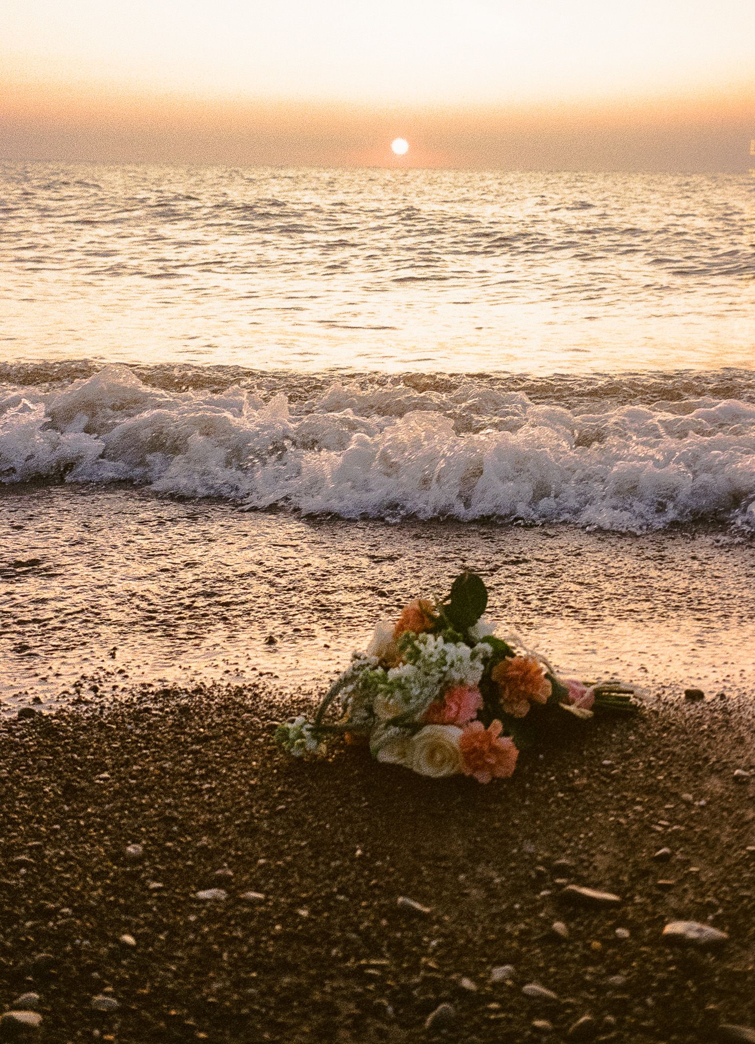 Film photograph of a wedding bouquet in golden light at Headlands Beach State Park, captured by a professional wedding photographer.