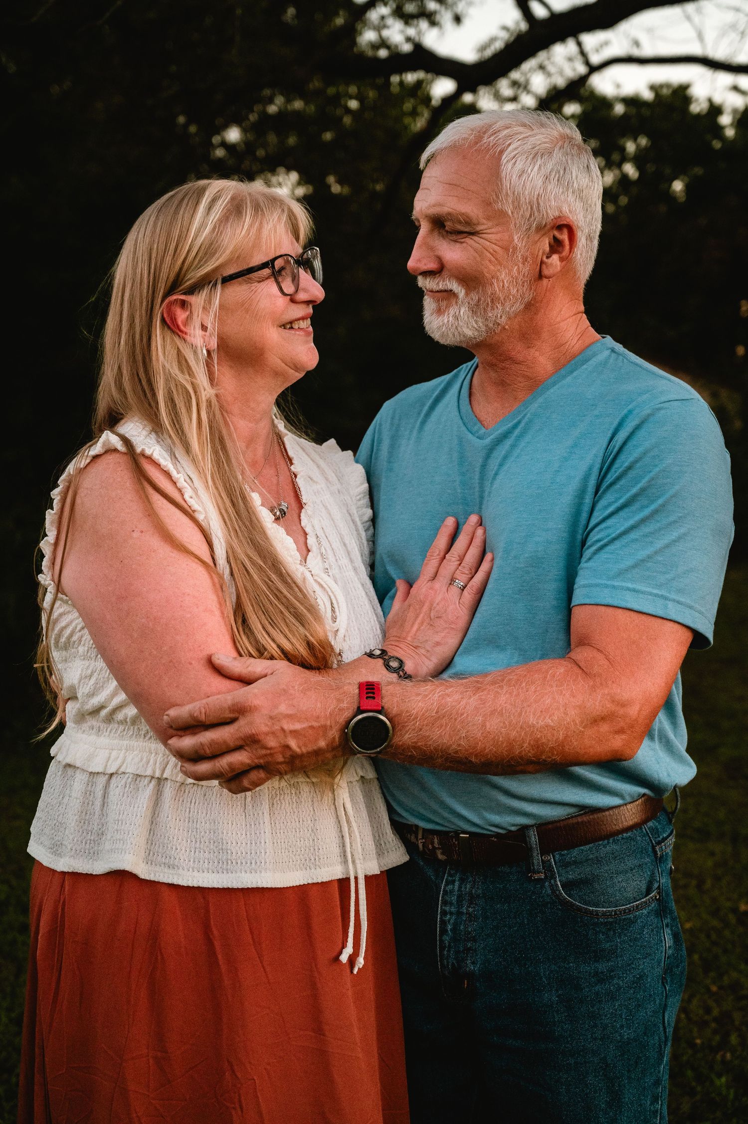 Loving couple embraces tenderly in a romantic outdoor photo series showing progression of intimate moments at sunset.
