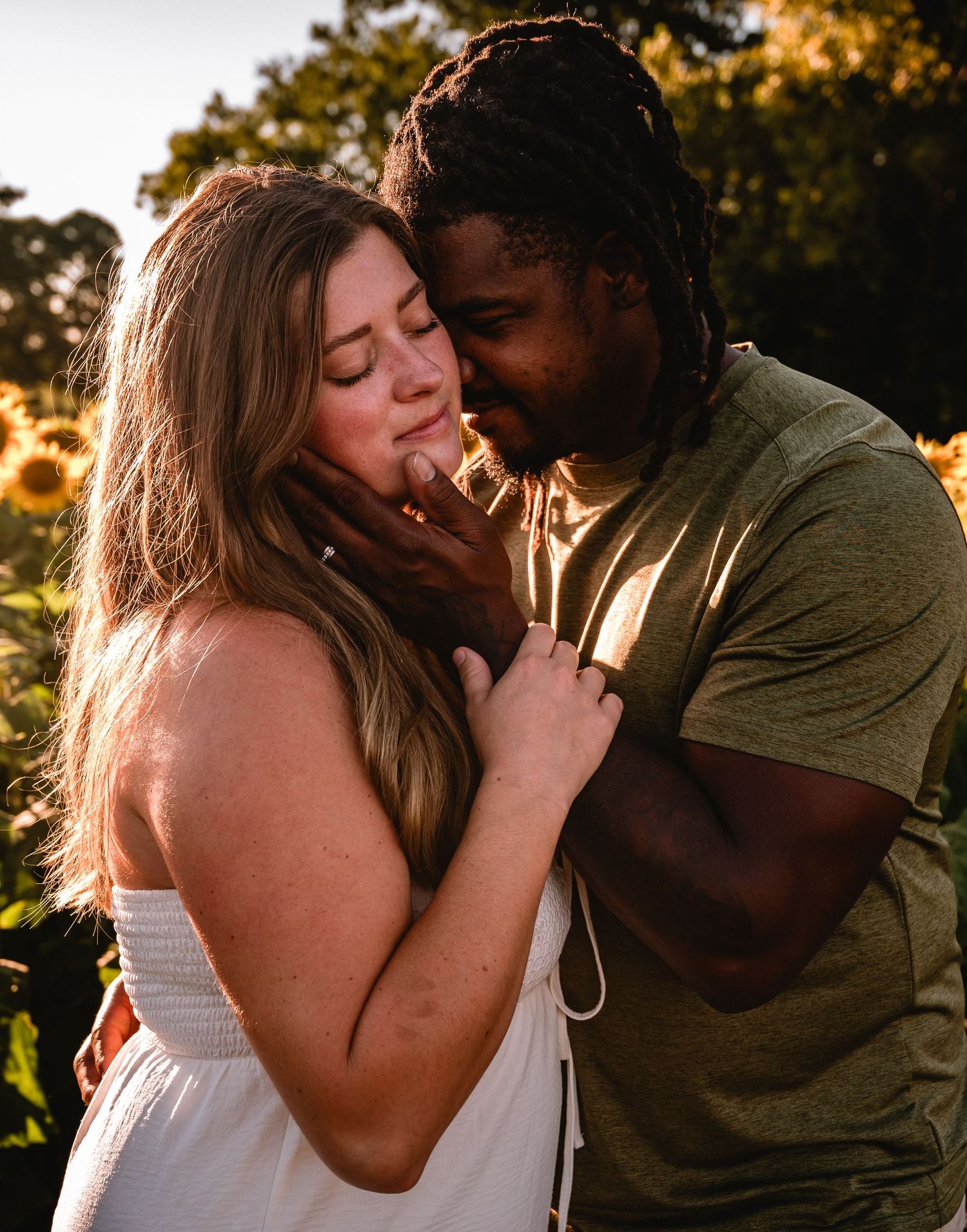 A couple shares intimate moments at sunset in a romantic outdoor photoshoot.