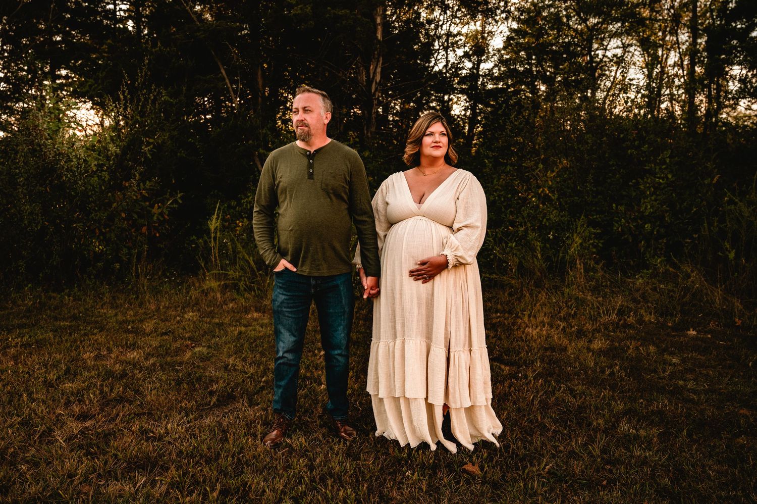 A couple shares an intimate moment together during a sunset photoshoot in a rustic outdoor setting.