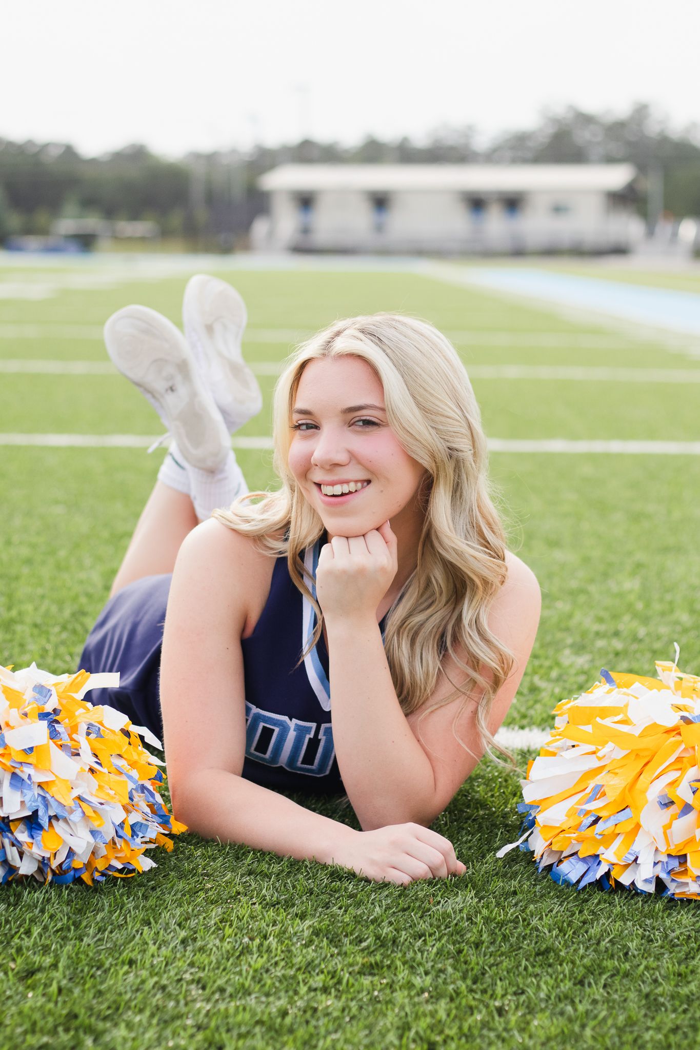 High school senior cheerleader posing for South Carolina photographer in Florence, SC for their senior pictures graduation portraits. Candid