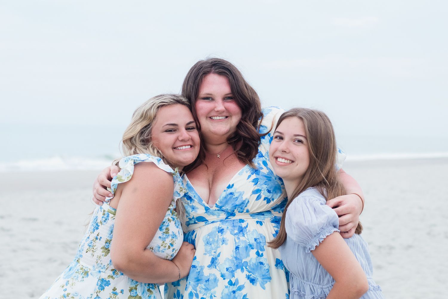 Three best friends posing for a South Carolina photographer in Garden City Beach, SC for their senior pictures graduation portraits.
