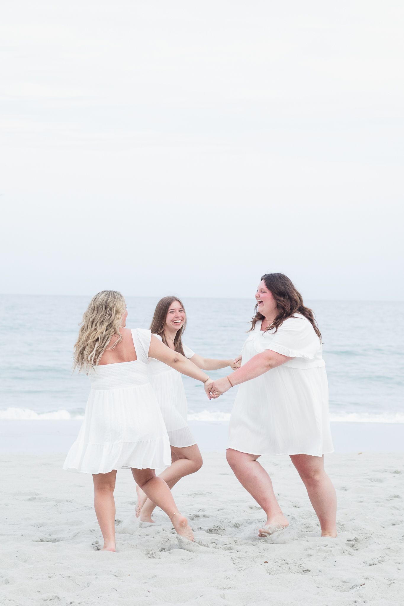 Three best friends posing for a South Carolina photographer in Garden City Beach, SC for their senior pictures graduation portraits.